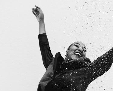 a woman in a black dress celebrating with confetti, black and white