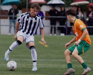 Dos jugadores de categoría juvenil nacional compitiendo por un balón, CD Castellón vs Valencia CF