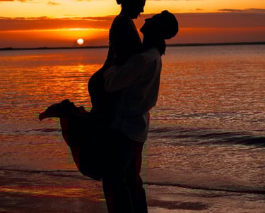 Couple enjoying a romantic Zanzibar sunset on a traditional dhow cruise, with vibrant orange skies reflected on the water