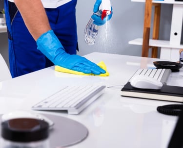 #profesional de limpieza limpiando escritorio de oficina.