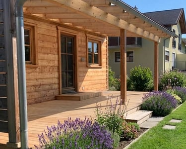 Überdachte Holzterrasse an einer Holzfassade im Garten von Holztechnik Volk am Ammersee