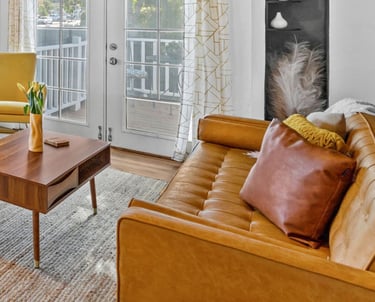 a living room with a couch, chairs, and a table