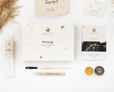 Kintsugi repair kit with gold powder, tools, and manual for mindful ceramic restoration at home.