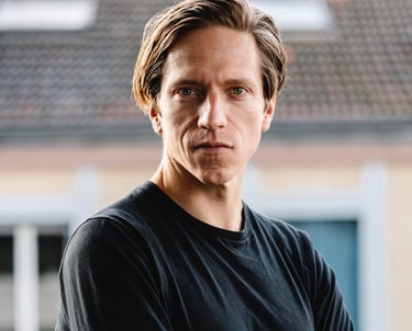 Portrait en extérieur homme blond qui croise les bras - book comédien - © Virginie Bouilhac