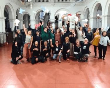Estudiantes de Noelia sonriendo y lanzando pañuelos al aire al finalizar la clase