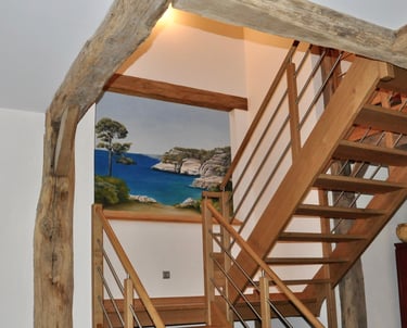 Fresque décorative dans une cage d'escalier représentant un paysage avec vue sur mer