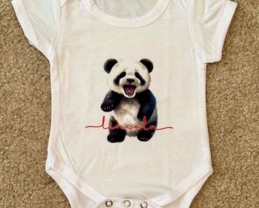 White baby onesie with a baby panda & personalized with child's name.