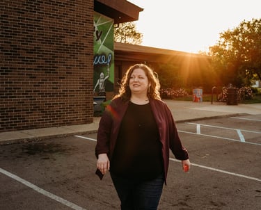 Confident woman walking with community center in background