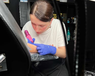 Tatuadora Sakine a fazer uma tatuagem no estúdio de tatuagens e body piercing em V