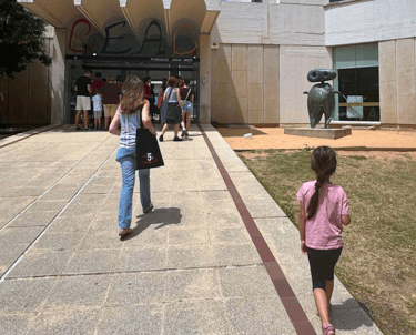 a woman walking with a child toward Barcelona Joan Miro museum