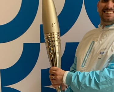 Tim Dougill holding the Paris24 Olympic torch.