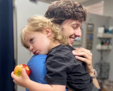 Child rests on Franklin Chiropractor's shoulder during adjustment to help him calm and rest