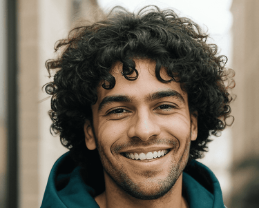 a man with curly hair and a green hoodie