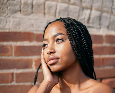 a black girl with black hair, caramel skin and a black dress