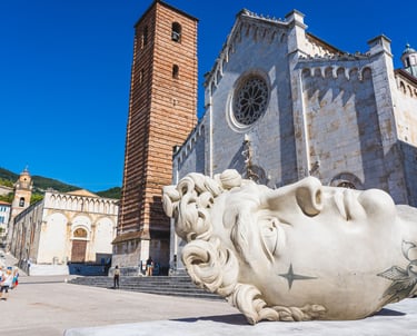 Giant marble head sculpture in Piazza Duomo Pietrasanta Tuscany.