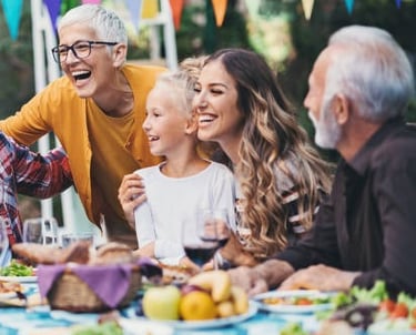 a group of people sitting around a table with food