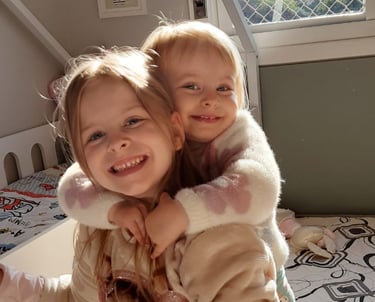two young children in a bed with a teddy bear