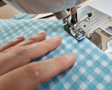 a person sewinging a piece of cloth
