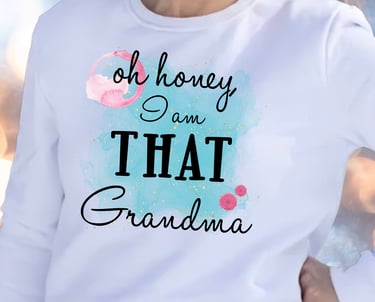 Woman in a white sweatshirt with a watercolor wash and the words "Oh honey I am THAT Grandma."