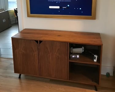 samsung the frame TV mounted on the wall with art light overhead in living room