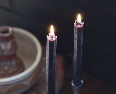 To svarte bivokslys som brenner på bordet