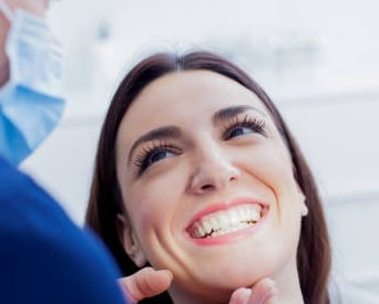 Paciente sorrindo em atendimento odontológico com dentista na Lapa PR
