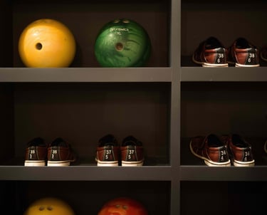 Bowling balls and shoes organized on shelves in the private bowling alley at Villa La Gratitud.