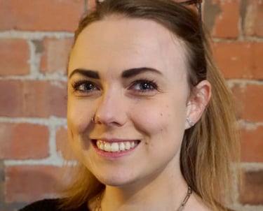 Coach Moll - a woman in her thirties with glasses and a black sweater