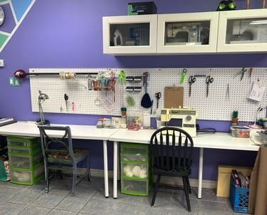 two desks with chairs, and a selection of sewing supplies and notions