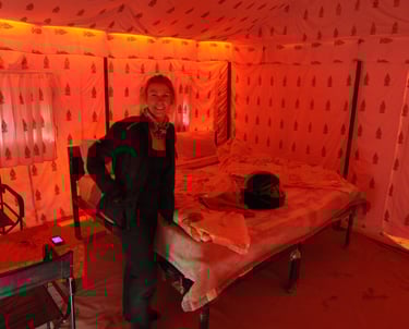 a man standing in a tented room with a bed and chairsTracey Billington riding the Leh to Manali high