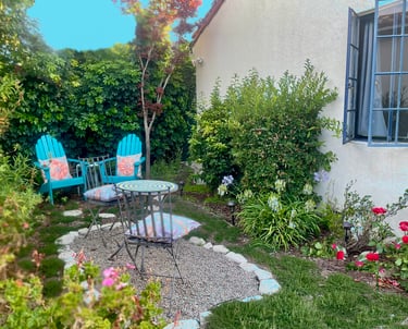 a patio with a table and chairs in the yard