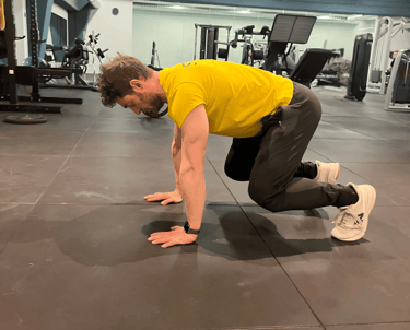 a man in a yellow shirt is doing a push up