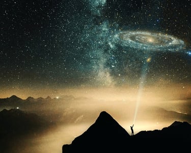 a person standing on a mountain top with a view of a galaxy