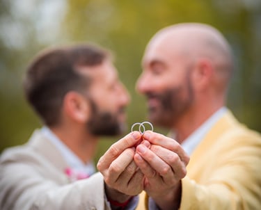 "Pareja gay casada mostrando sus anillos de boda en Madrid, celebrando su amor y unión."