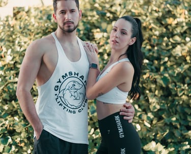"Pareja heterosexual de novios posando con ropa de gimnasio, mostrando su complicidad y estilo."