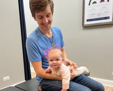 Joyful baby receiving gentle chiropractic care for sleep and digestion