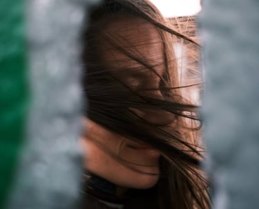 a woman with long hair and a black jacket. wind is blowing in the hair.