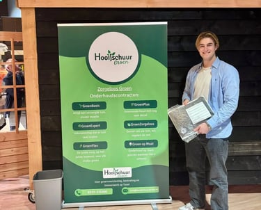 Jelle de Porto naast een banner van Hooijschuur groen