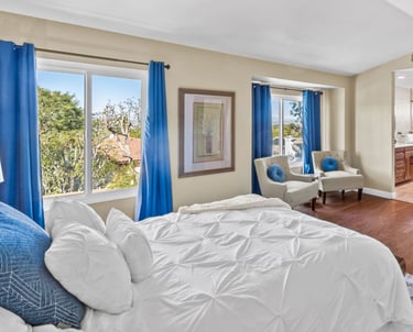 a bedroom with a bed and a large window
