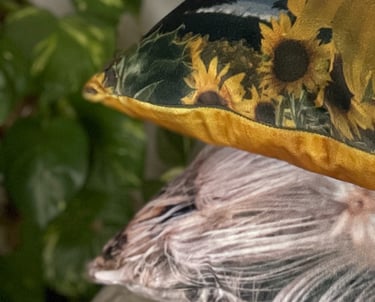 A cushion stack of luxury velvet cushions featuring sunflowers and thistledown photographic images