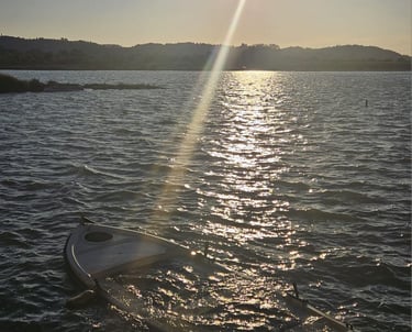 a surfboarder is sitting on the water