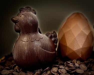 une poule chocolat noir accompagnée de son oeuf origami au chocolat au lait pour pâques