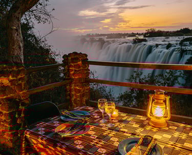 Outdoor Zambian dinner setup under the stars overlooking Victoria Falls