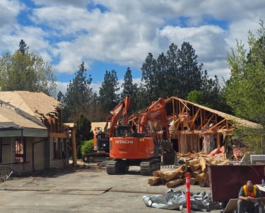 Two excavators demolishing a large structure