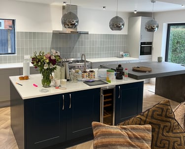A modern kitchen with navy cabinets and a kitchen island. 