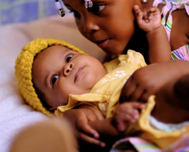 a baby girl in a yellow dress and a yellow hat