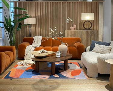 a living room with a sofa a armchair and a table and a console and accessories