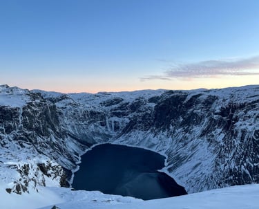 Frozen alpine lake in the Norway Alps, surrounded by snow-covered mountains and winter landscapes