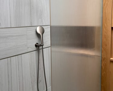 fluted tiles and shower screen with brushed stainless shower head