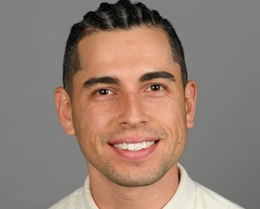 Daniel Alvarez in a cream shirt and tie 